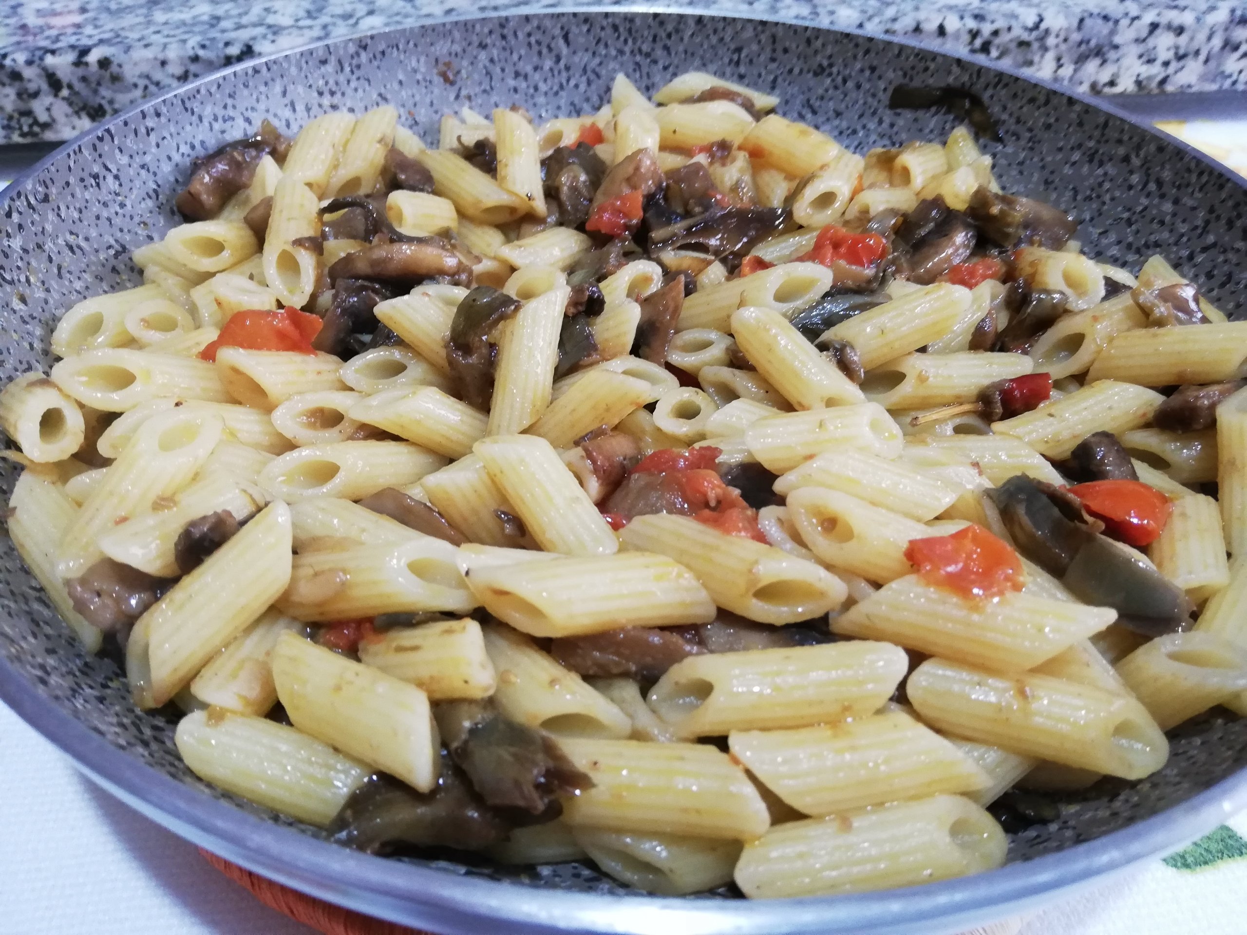 Pennette con funghi carciofi pomodorini e guanciale