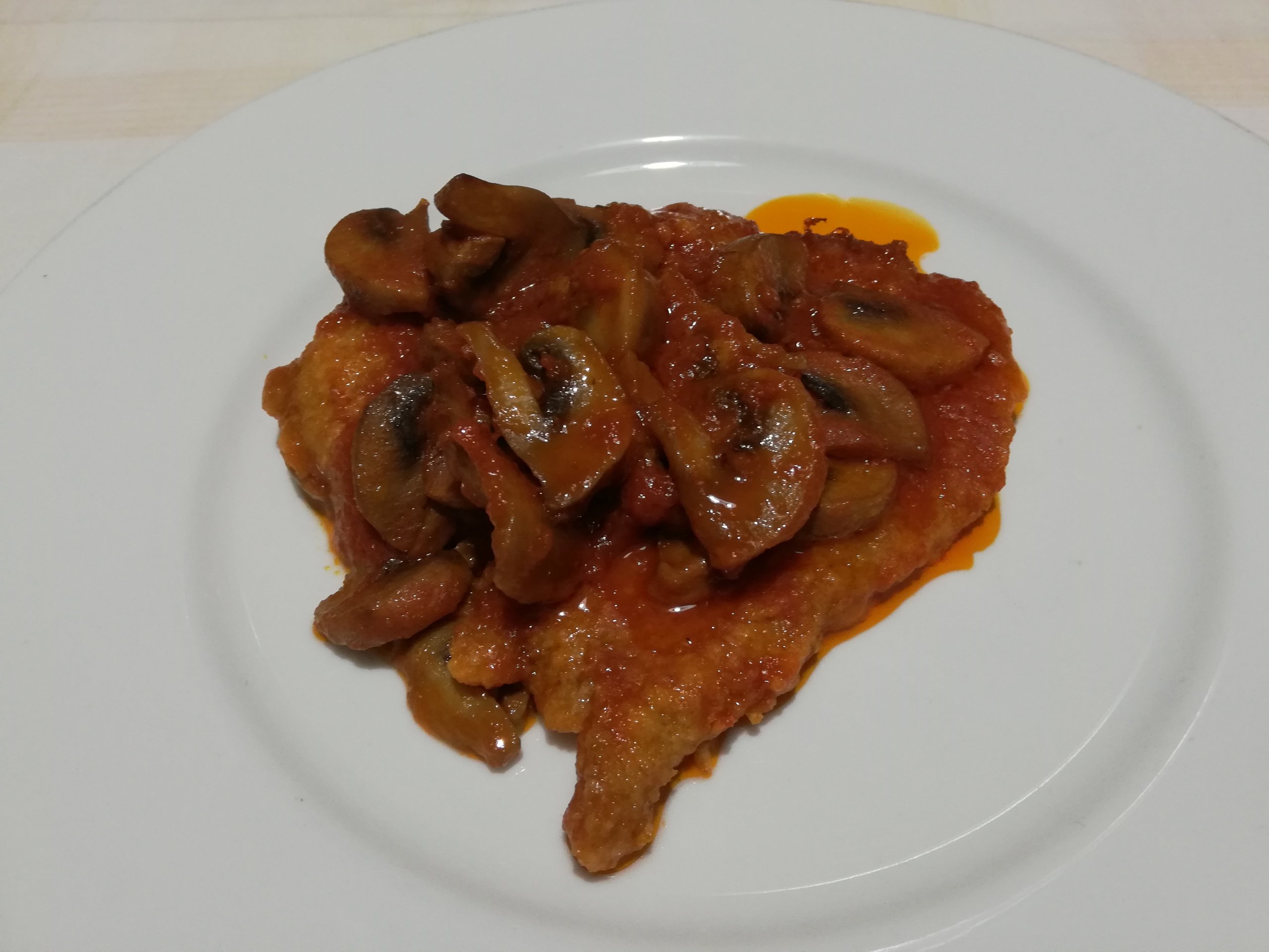 Fettine panate e infornate nel sugo di funghi
