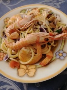 Dopo aver fatto rosolare lo spicchio d’aglio in una padella antiaderente con dell’olio extra vergine d’oliva, aggiungere i polpetti piccoli, sminuzzati con le forbici. Questo ingrediente va prima degli altri perché ha una cottura un po' più lunga. Quando i polpetti saranno un po' rosolati, girandoli man mano con un cucchiaio di legno, si potranno mettere anche scampi e mazzancolle. Far insaporire il tutto per qualche minuto a fiamma vivace. A questo punto, sfumare con del vino bianco, poi aggiungere le telline, che avremo fatto precedentemente aprire. Annalisa ci suggerisce che al posto delle telline si possono usare altri tipi di molluschi tipo vongole, fasolari e cozze. Continuare a cuocere per qualche minuto, aggiungendo due pomodorini pachino tagliati a metà (lasciate la buccia). Una volta cotti i pomodorini, aggiustate di sale e aggiungete, a piacere, un po' di peperoncino. Spegnete quindi il fuoco e mettete delle foglioline di prezzemolo sminuzzato. Consiglio di Annalisa: quando si aggiungono le telline, o un altro pesce col guscio, unite anche il sughetto di cottura che servirà ad insaporire tutto il piatto. Nel frattempo avremo cotto la pasta in abbondante acqua salata. Una volta mantecata non vi resterà che impiattarla e così gustare i vostri spaghettoni allo scoglio!
