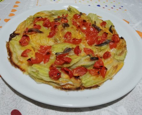 Fiori di zucca in pastella al forno con pomodorini e alici